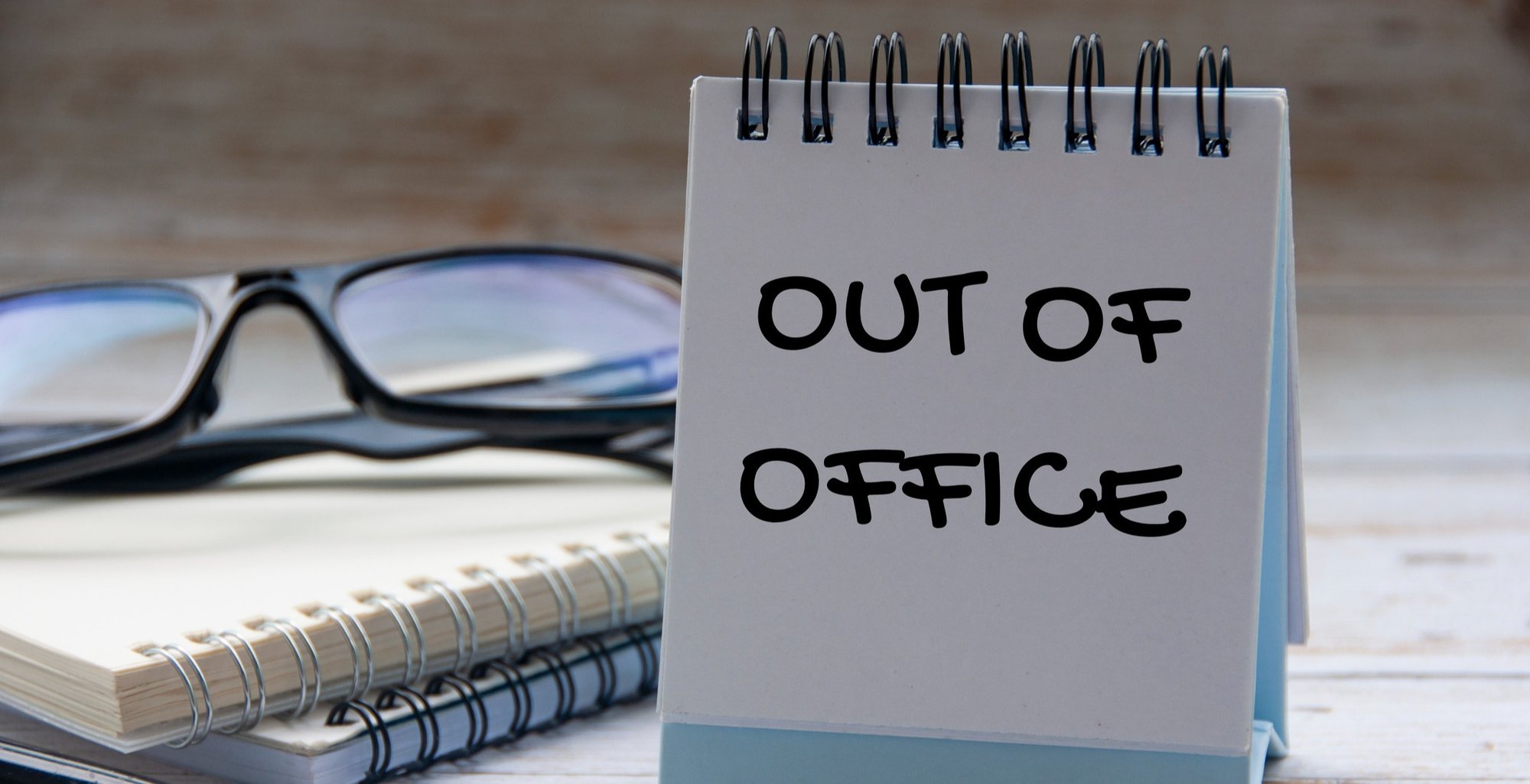 An out of office sign on a desk.